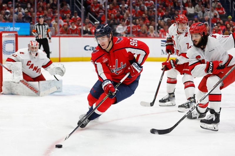 Jan 5, 2024; Washington, District of Columbia, USA; Washington Capitals right wing Nicolas Aube-Kubel (96) skates with the puck as Carolina Hurricanes defenseman Jalen Chatfield (5) defends in the third period at Capital One Arena. Mandatory Credit: Geoff Burke-USA TODAY Sports