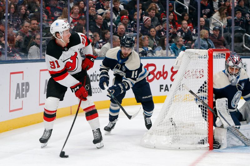 Dec 31, 2025; Columbus, Ohio, USA; New Jersey Devils center Dawson Mercer (91) passes the puck as Columbus Blue Jackets center Adam Fantilli (19) trails the play during the first period at Nationwide Arena. Mandatory Credit: Russell LaBounty-Imagn Images