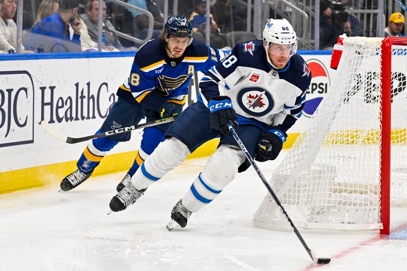 Nov 7, 2023; St. Louis, Missouri, USA;  Winnipeg Jets defenseman Nate Schmidt (88) controls the puck against St. Louis Blues center Robert Thomas (18) during the second period at Enterprise Center. Mandatory Credit: Jeff Curry-USA TODAY Sports