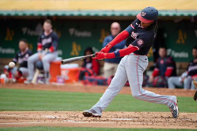 Apr 14, 2024; Oakland, California, USA; Washington Nationals shortstop CJ Abrams (5) hits a single against the Oakland Athletics during the third inning at Oakland-Alameda County Coliseum. Mandatory Credit: Robert Edwards-USA TODAY Sports