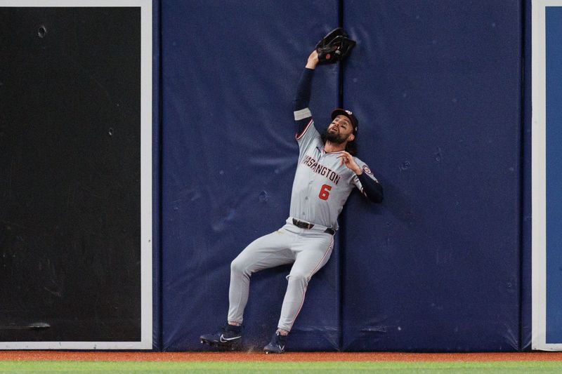 Jun 28, 2024; St. Petersburg, Florida, USA;  Washington Nationals outfielder Jesse Winker (6) makes a catch at the wall against the Tampa Bay Rays in the first inning at Tropicana Field. Mandatory Credit: Nathan Ray Seebeck-USA TODAY Sports