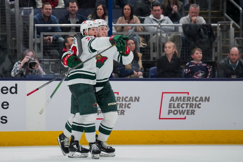 Jan 6, 2024; Columbus, Ohio, USA;  Minnesota Wild center Marco Rossi (23) celebrates with teammate defenseman Brock Faber (7) after scoring the game-winning goal against the Columbus Blue Jackets in the overtime period at Nationwide Arena. Mandatory Credit: Aaron Doster-USA TODAY Sports