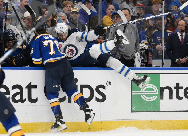Apr 27, 2025; St. Louis, Missouri, USA; St. Louis Blues right wing Zack Bolduc (76) finishes a check on Winnipeg Jets center Mason Appleton (22) during the third period in game four of the first round of the 2025 Stanley Cup Playoffs at Enterprise Center. Mandatory Credit: Jeff Le-Imagn Images