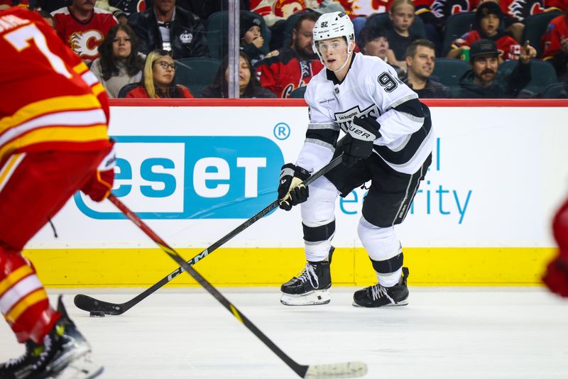 Nov 11, 2024; Calgary, Alberta, CAN; Los Angeles Kings defenseman Brandt Clarke (92) controls the puck against the Calgary Flames during the first period at Scotiabank Saddledome. Mandatory Credit: Sergei Belski-Imagn Images