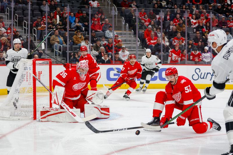 Jan 27, 2026; Detroit, Michigan, USA; Los Angeles Kings defenseman Brian Dumoulin (2) takes a shot on Detroit Red Wings goaltender John Gibson (36) while defenseman Travis Hamonic (52) tries to block his shot during the first period at Little Caesars Arena. Mandatory Credit: Brian Bradshaw Sevald-Imagn Images