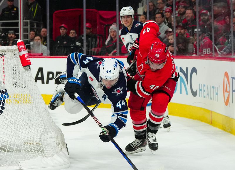 Mar 2, 2024; Raleigh, North Carolina, USA; Carolina Hurricanes left wing Jordan Martinook (48) trips Winnipeg Jets defenseman Josh Morrissey (44) during the first period at PNC Arena. Mandatory Credit: James Guillory-USA TODAY Sports