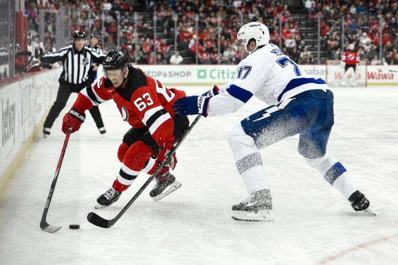 Feb 25, 2024; Newark, New Jersey, USA; New Jersey Devils left wing Jesper Bratt (63) skates with the puck while being defended by Tampa Bay Lightning defenseman Victor Hedman (77) during the second period at Prudential Center. Mandatory Credit: John Jones-USA TODAY Sports