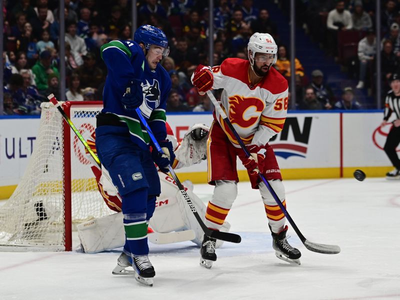 Mar 23, 2024; Vancouver, British Columbia, CAN; Vancouver Canucks forward Nils Hoglander (21) checks Calgary Flames defenseman Olivver Kylington (58) during the first period at Rogers Arena. Mandatory Credit: Simon Fearn-USA TODAY Sports