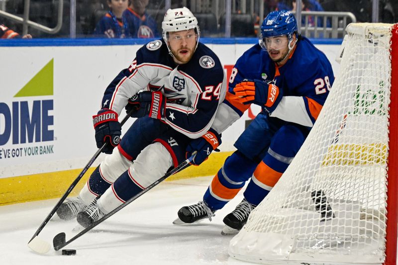 Nov 2, 2025; Elmont, New York, USA;  Columbus Blue Jackets right wing Mathieu Olivier (24) skates the puck from behind the net chased by New York Islanders defenseman Alexander Romanov (28) during the first period at UBS Arena. Mandatory Credit: Dennis Schneidler-Imagn Images