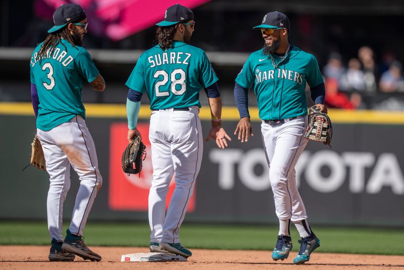 Sep 13, 2023; Seattle, Washington, USA; Seattle Mariners right fielder Teoscar Hernandez (35), right, shortstop J.P. Crawford (3) and third baseman Eugenio Suarez (28) celebrate after a game against the Los Angeles Angels at T-Mobile Park. Mandatory Credit: Stephen Brashear-USA TODAY Sports