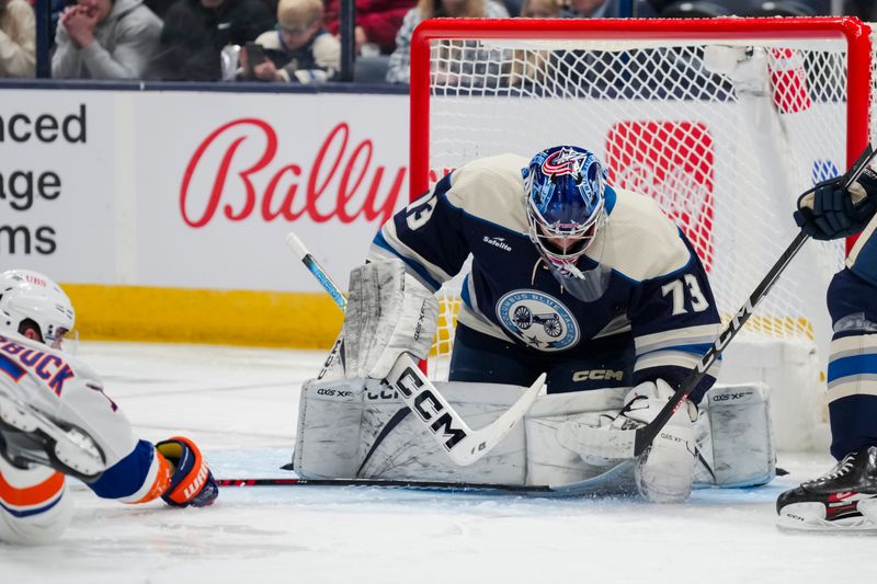 Apr 4, 2024; Columbus, Ohio, USA;  Columbus Blue Jackets goaltender Jet Greaves (73) makes a save against New York Islanders right wing Cal Clutterbuck (15) in the second period at Nationwide Arena. Mandatory Credit: Aaron Doster-USA TODAY Sports