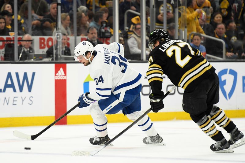 Apr 20, 2024; Boston, Massachusetts, USA; Toronto Maple Leafs center Auston Matthews (34) controls the puck while Boston Bruins defenseman Hampus Lindholm (27) defends during the second period in game one of the first round of the 2024 Stanley Cup Playoffs at TD Garden. Mandatory Credit: Bob DeChiara-USA TODAY Sports