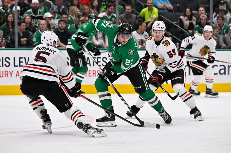 Oct 26, 2024; Dallas, Texas, USA; Dallas Stars left wing Mason Marchment (27) controls the puck between Chicago Blackhawks defenseman Connor Murphy (5) and left wing Tyler Bertuzzi (59) during the second period at the American Airlines Center. Mandatory Credit: Jerome Miron-Imagn Images