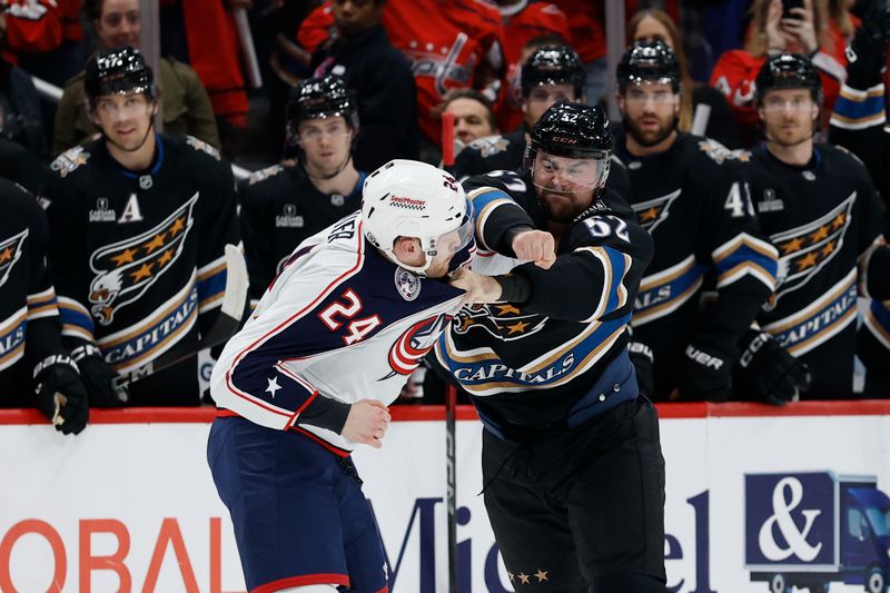 Apr 13, 2025; Washington, District of Columbia, USA; Washington Capitals defenseman Dylan McIlrath (52) fights Columbus Blue Jackets right wing Mathieu Olivier (24) in the first period at Capital One Arena. Mandatory Credit: Geoff Burke-Imagn Images