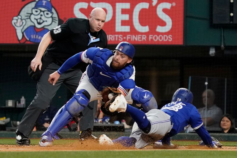 Sep 19, 2024; Arlington, Texas, USA; Toronto Blue Jays third baseman Ernie Clement (28) is tagged out trying to scoring by Texas Rangers catcher Carson Kelly (18) during the fourth inning at Globe Life Field. Mandatory Credit: Raymond Carlin III-Imagn Images