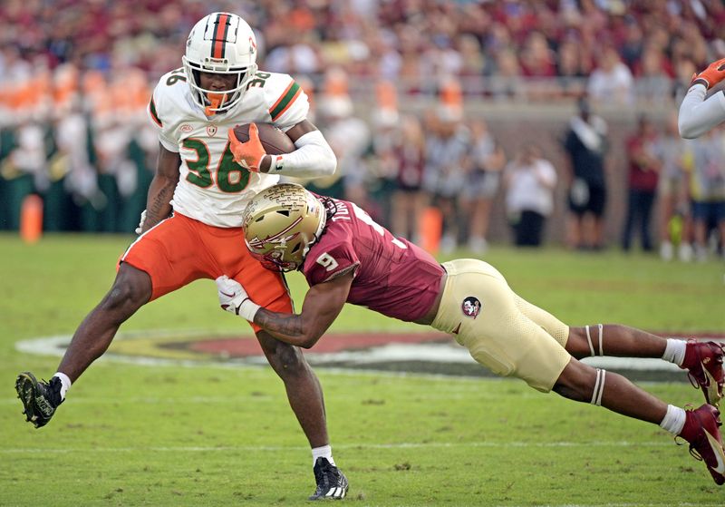 Nov 11, 2023; Tallahassee, Florida, USA; Miami Hurricanes wide receiver Brashard Smith (36) returns a punt as he is tackled by Florida State Seminoles running back Lawrance Toafili (9) during the game at Doak S. Campbell Stadium. Mandatory Credit: Melina Myers-USA TODAY Sports