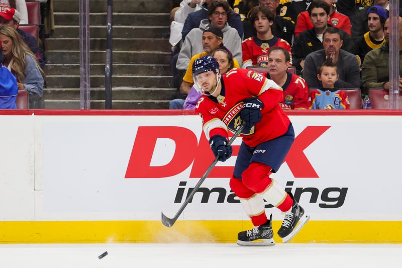 Nov 22, 2023; Sunrise, Florida, USA; Florida Panthers center Sam Reinhart (13) passes the puck against the Boston Bruins during the first period at Amerant Bank Arena. Mandatory Credit: Sam Navarro-USA TODAY Sports