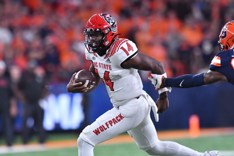 Oct 15, 2022; Syracuse, New York, USA; North Carolina State Wolfpack quarterback Jack Chambers (14) runs for a first down against the Syracuse Orange in the fourth quarter at JMA Wireless Dome. Mandatory Credit: Mark Konezny-USA TODAY Sports