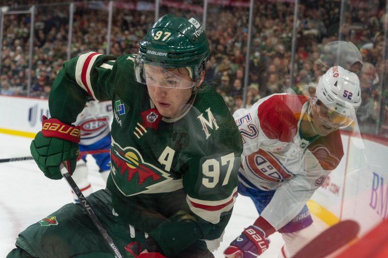 Dec 21, 2023; Saint Paul, Minnesota, USA; Minnesota Wild left wing Kirill Kaprizov (97) checked by Montreal Canadiens defenseman Justin Barron (52) in the third period at Xcel Energy Center. Mandatory Credit: Matt Blewett-USA TODAY Sports