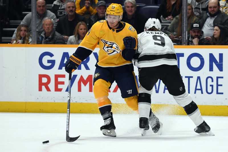 Jan 31, 2024; Nashville, Tennessee, USA; Nashville Predators center Gustav Nyquist (14) loses the puck as he is hit by Los Angeles Kings right wing Adrian Kempe (9) during the first period at Bridgestone Arena. Mandatory Credit: Christopher Hanewinckel-USA TODAY Sports