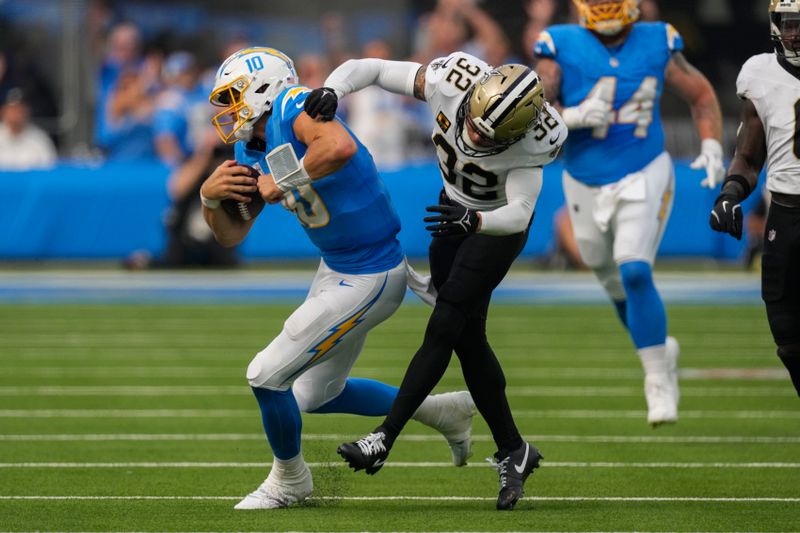 Los Angeles Chargers quarterback Justin Herbert (10) is hit by New Orleans Saints safety Tyrann Mathieu (32) on a 38 yard run in the first half of an NFL football game in Inglewood, Calif., Sunday, Oct. 27, 2024. (AP Photo/Mark J. Terrill)