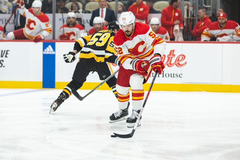 Oct 14, 2023; Pittsburgh, Pennsylvania, USA; Calgary Flames defenseman MacKenzie Weegar (52) skates the puck past Pittsburgh Penguins left winger Jake Guentzel (59) during the first period at PPG Paints Arena. Mandatory Credit: Scott Galvin-USA TODAY Sports