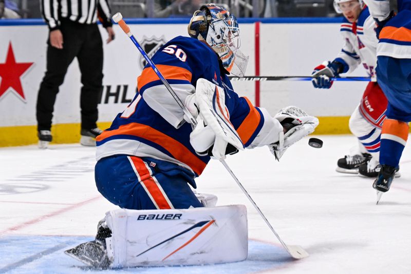 Apr 10, 2025; Elmont, New York, USA;  New York Islanders goaltender Marcus Hogberg (50) makes a save against the New York Rangers during the third period at UBS Arena. Mandatory Credit: Dennis Schneidler-Imagn Images