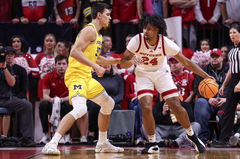 Feb 1, 2025; Piscataway, New Jersey, USA; Rutgers Scarlet Knights center Lathan Sommerville (24) dribbles asMichigan Wolverines center Vladislav Goldin (50) defends during the first half at Jersey Mike's Arena. Mandatory Credit: Vincent Carchietta-Imagn Images