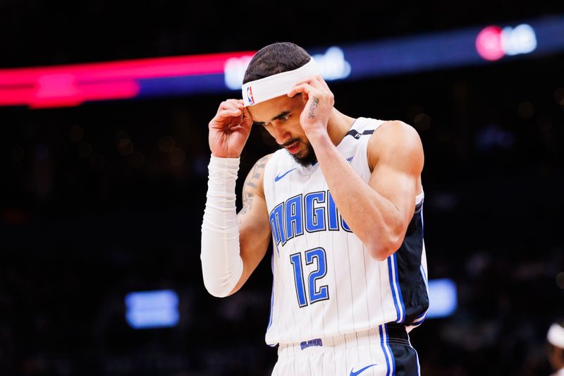 TORONTO, CANADA - JANUARY 3: Trevelin Queen #12 of the Orlando Magic fixes his headband during second half of their NBA game against the Toronto Raptors at Scotiabank Arena on January 3, 2025 in Toronto, Canada. NOTE TO USER: User expressly acknowledges and agrees that, by downloading and or using this photograph, User is consenting to the terms and conditions of the Getty Images License Agreement. (Photo by Cole Burston/Getty Images)