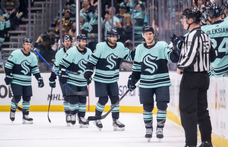 Feb 23, 2023; Seattle, Washington, USA; Seattle Kraken forward Yanni Gourde (37), right, is congratulated by teammates on the bench after scoring a goal during the second period against the Boston Bruins at Climate Pledge Arena. Mandatory Credit: Stephen Brashear-USA TODAY Sports