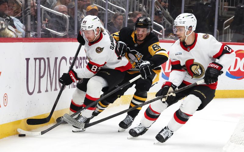 Feb 2, 2026; Pittsburgh, Pennsylvania, USA;  Pittsburgh Penguins right wing Rickard Rakell (67) moves the puck against Ottawa Senators defenseman Jake Sanderson (85) and defenseman Artem Zub (2) during the third period at PPG Paints Arena. Mandatory Credit: Charles LeClaire-Imagn Images