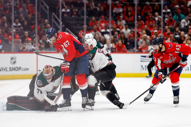 Mar 3, 2024; Washington, District of Columbia, USA; Arizona Coyotes goaltender Karel Vejmelka (70) makes a save in front of Washington Capitals left wing Max Pacioretty (67) and Arizona Coyotes defenseman Troy Stecher (51) in the third period at Capital One Arena. Mandatory Credit: Geoff Burke-USA TODAY Sports