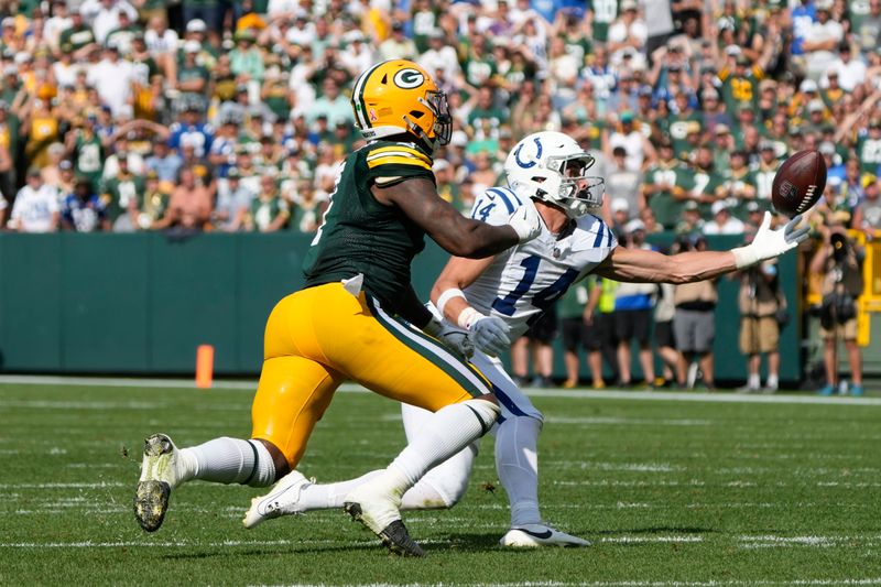 Indianapolis Colts wide receiver Alec Pierce (14) catches a deflected pass in front of Green Bay Packers linebacker Quay Walker (7) during the second half of an NFL football game Sunday, Sept. 15, 2024, in Green Bay, Wis. (AP Photo/Morry Gash)