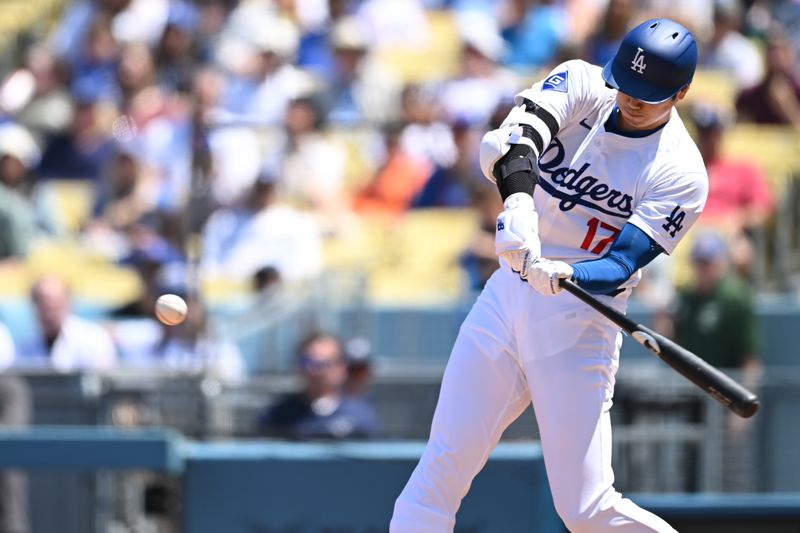 Apr 21, 2024; Los Angeles, California, USA; Los Angeles Dodgers designated hitter Shohei Ohtani (17) his a one run home run against the New York Mets during the third inning at Dodger Stadium. Mandatory Credit: Jonathan Hui-USA TODAY Sports