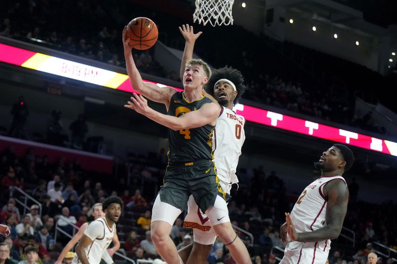 Jan 14, 2025; Los Angeles, California, USA; (EDITORS NOTE: blood)  Iowa Hawkeyes guard Josh Dix (4) shoots the ball against Southern California Trojans forward Saint Thomas (0) in the first half at Galen Center. Mandatory Credit: Kirby Lee-Imagn Images