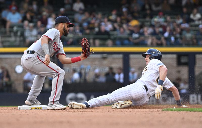 Sep 17, 2023; Milwaukee, Wisconsin, USA; Milwaukee Brewers left fielder Mark Canha (21) slides in safely ahead of the tag by Washington Nationals second baseman Luis Garcia (2) in the sixth inning at American Family Field. Mandatory Credit: Michael McLoone-USA TODAY Sports