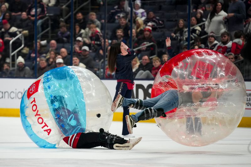 Nov 23, 2024; Columbus, Ohio, USA;  Fans collide on the ice as they compete in a game, between periods in the game between the Carolina Hurricanes and the Columbus Blue Jackets at Nationwide Arena. Mandatory Credit: Aaron Doster-Imagn Images