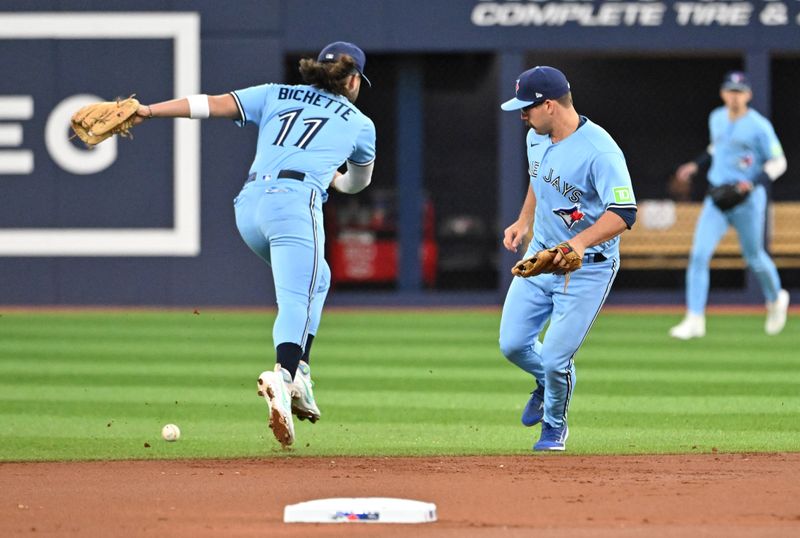 Sep 14, 2023; Toronto, Ontario, CAN;   Toronto Blue Jays shortstop Bo Bichette (11) and second baseman Davis Schneider (36) misplay a ball hit for a single by Texas Rangers right fielder Robbie Grossman (not pictured) in the first inning at Rogers Centre. Mandatory Credit: Dan Hamilton-USA TODAY Sports