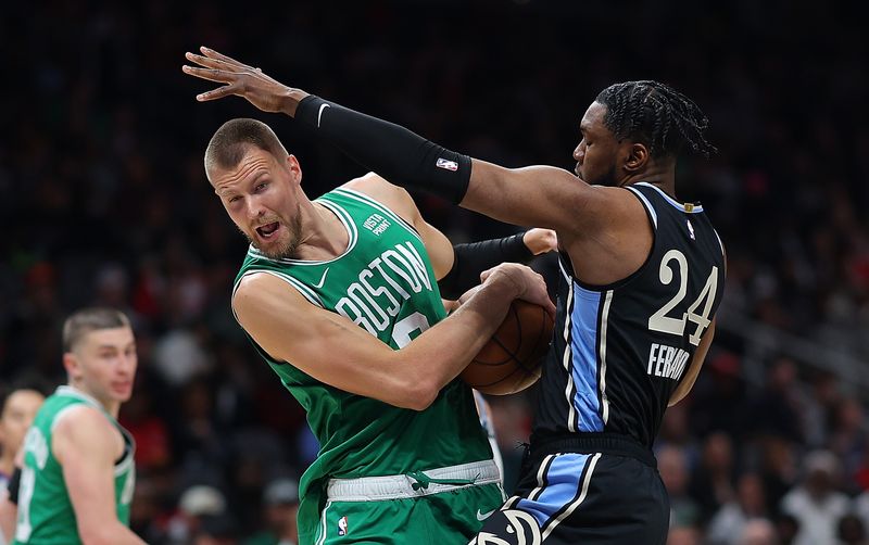 ATLANTA, GEORGIA - MARCH 25:  Kristaps Porzingis #8 of the Boston Celtics draws a foul as he drives against Bruno Fernando #24 of the Atlanta Hawks during the first quarter at State Farm Arena on March 25, 2024 in Atlanta, Georgia.  NOTE TO USER: User expressly acknowledges and agrees that, by downloading and/or using this photograph, user is consenting to the terms and conditions of the Getty Images License Agreement. (Photo by Kevin C. Cox/Getty Images)