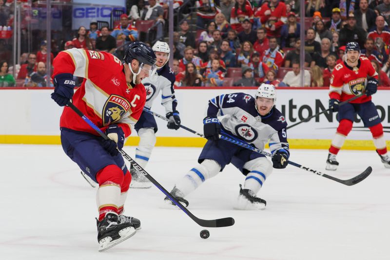 Nov 24, 2023; Sunrise, Florida, USA; Florida Panthers center Aleksander Barkov (16) moves the puck against the Winnipeg Jets during the second period at Amerant Bank Arena. Mandatory Credit: Sam Navarro-USA TODAY Sports