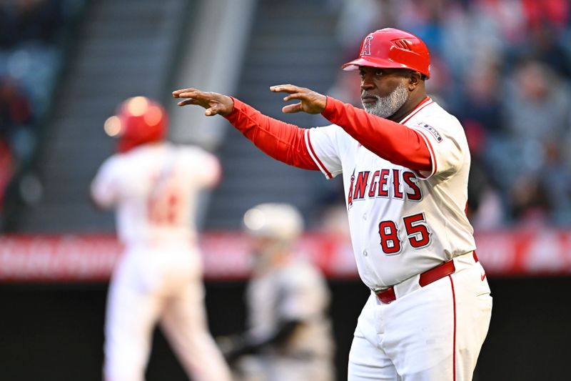 May 3, 2025; Anaheim, California, USA; Los Angeles Angels third base coach Eric Young Sr. (85) signals to Los shortstop Zach Neto (9) against the Detroit Tigers during the first inning at Angel Stadium. Mandatory Credit: Jonathan Hui-Imagn Images