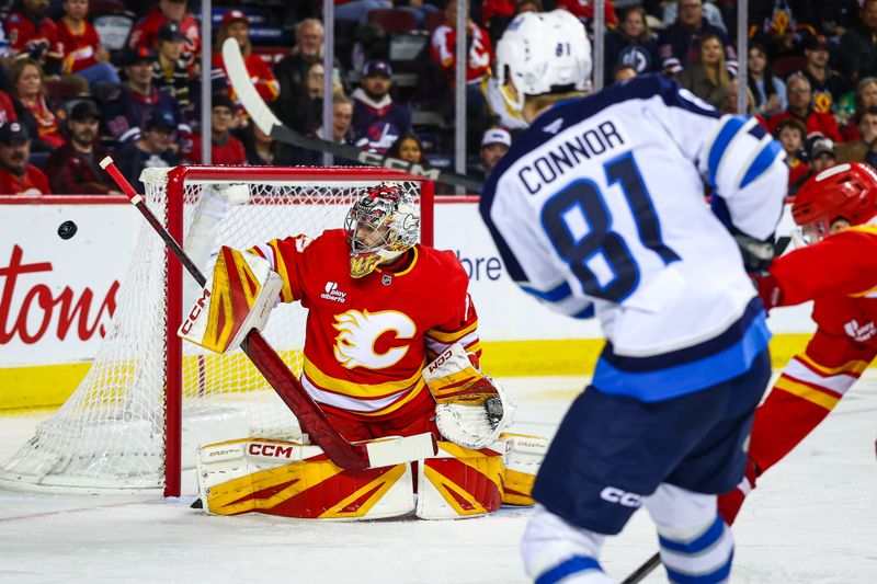 Nov 15, 2025; Calgary, Alberta, CAN; Calgary Flames goaltender Dustin Wolf (32) makes a save against Winnipeg Jets left wing Kyle Connor (81) during the third period at Scotiabank Saddledome. Mandatory Credit: Sergei Belski-Imagn Images
