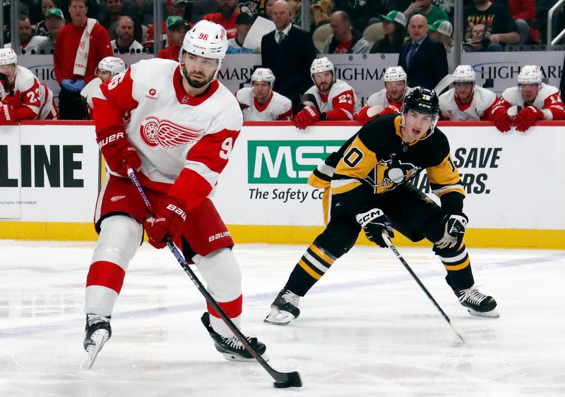 Mar 17, 2024; Pittsburgh, Pennsylvania, USA;  Detroit Red Wings defenseman Jake Walman (96) moves the puck against Pittsburgh Penguins left wing Drew O'Connor (10) during the first period at PPG Paints Arena. Mandatory Credit: Charles LeClaire-USA TODAY Sports