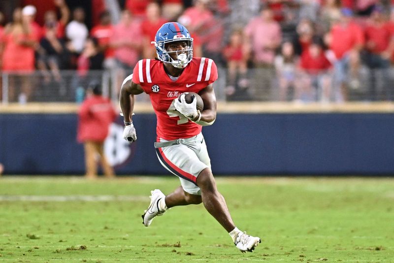 Sep 10, 2022; Oxford, Mississippi, USA; Ole Miss Rebels running back Quinshon Judkins (4) runs the ball against the Central Arkansas Bears during the second quarter at Vaught-Hemingway Stadium. Mandatory Credit: Matt Bush-USA TODAY Sports