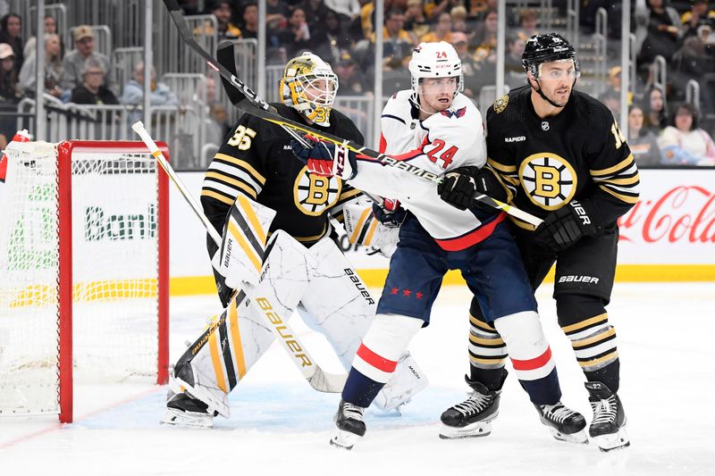 Oct 3, 2023; Boston, Massachusetts, USA; Washington Capitals center Connor McMichael (24) battles with Boston Bruins defenseman Kevin Shattenkirk (12) in front of goaltender Linus Ullmark (35) during the second period at TD Garden. Mandatory Credit: Bob DeChiara-USA TODAY Sports