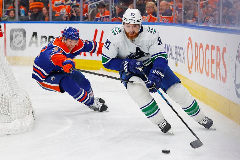 Apr 13, 2024; Edmonton, Alberta, CAN; Vancouver Canucks defensemen Ian Cole (82) moves the puck in front of Edmonton Oilers forward Warren Foegele (37) during the third period at Rogers Place. Mandatory Credit: Perry Nelson-USA TODAY Sports