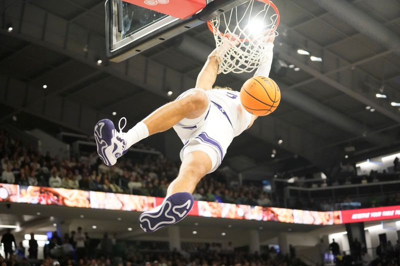 Jan 7, 2024; Evanston, Illinois, USA; Northwestern Wildcats guard Ty Berry (3) dunks on Michigan State Spartans guard Tre Holloman (5) during the second half at Welsh-Ryan Arena. Mandatory Credit: David Banks-USA TODAY Sports