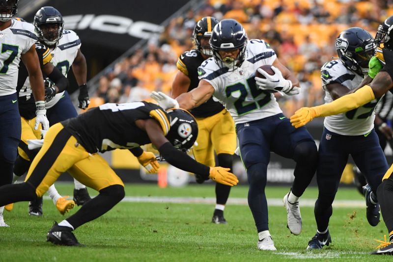 Seattle Seahawks running back Travis Homer (25) tries to avoid Pittsburgh Steelers safety Damontae Kazee (24) on a run during the first half of a preseason NFL football game, Saturday, Aug. 13, 2022, in Pittsburgh. (AP Photo/Barry Reeger)