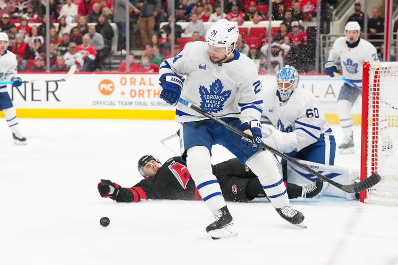 Dec 4, 2025; Raleigh, North Carolina, USA; Toronto Maple Leafs center Scott Laughton (24) pick up the rebound shot from Carolina Hurricanes center Logan Stankoven (22) during the first period at Lenovo Center. Mandatory Credit: James Guillory-Imagn Images