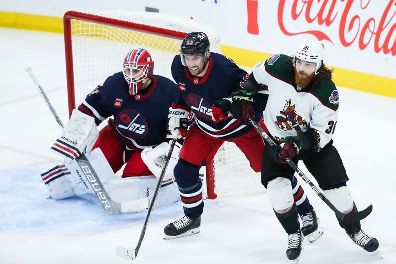 Nov 18, 2023; Winnipeg, Manitoba, CAN;  Winnipeg Jets forward David Gustafsson (19) jostles for position with Arizona Coyotes forward Liam O'Brien (38) in front of Winnipeg Jets goalie Laurent Boissoit (39) during the third period at Canada Life Centre. Mandatory Credit: Terrence Lee-USA TODAY Sports